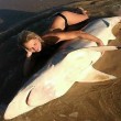 Ragazza cavalca uno squalo in spiaggia FOTO
