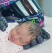 Neonata tra i guanti da moto del papà