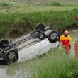 Auto ribaltata nel canale FOTO passante lo salva tenendogli la testa