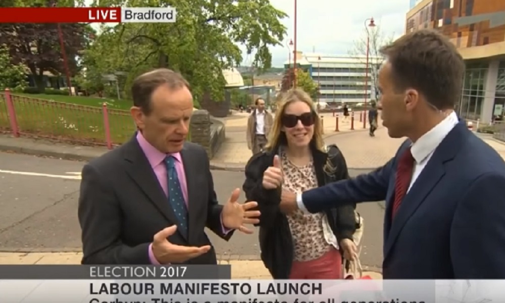 YOUTUBE Il giornalista allontana la disturbatrice e la tocca... Lei reagisce così