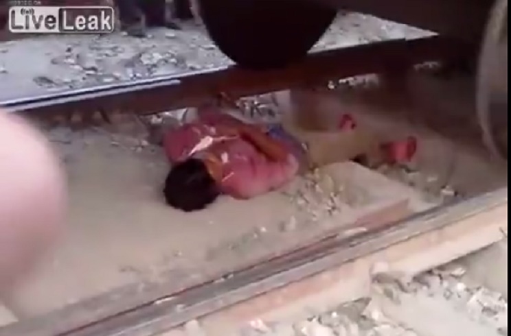 Si sdraia sui binari e resta immobile al centro: treno gli passa sopra