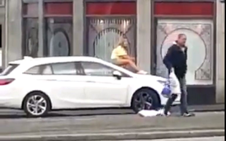 Litiga in strada col marito e si spoglia: poi si siede sul cofano e resta là VIDEO