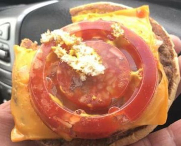 Hamburger, sta per morderlo poi... c'è un coperchio di plastica al posto del pomodoro