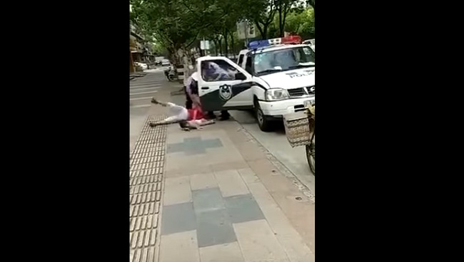 YOUTUBE Cina: poliziotto dà un pugno a una mamma con il figlio in braccio