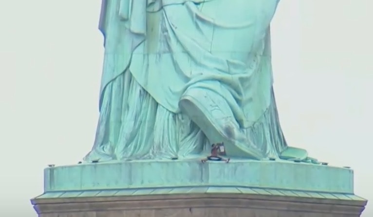 YOUTUBE New York, donna sulla Statua della Libertà. Protesta contro Trump