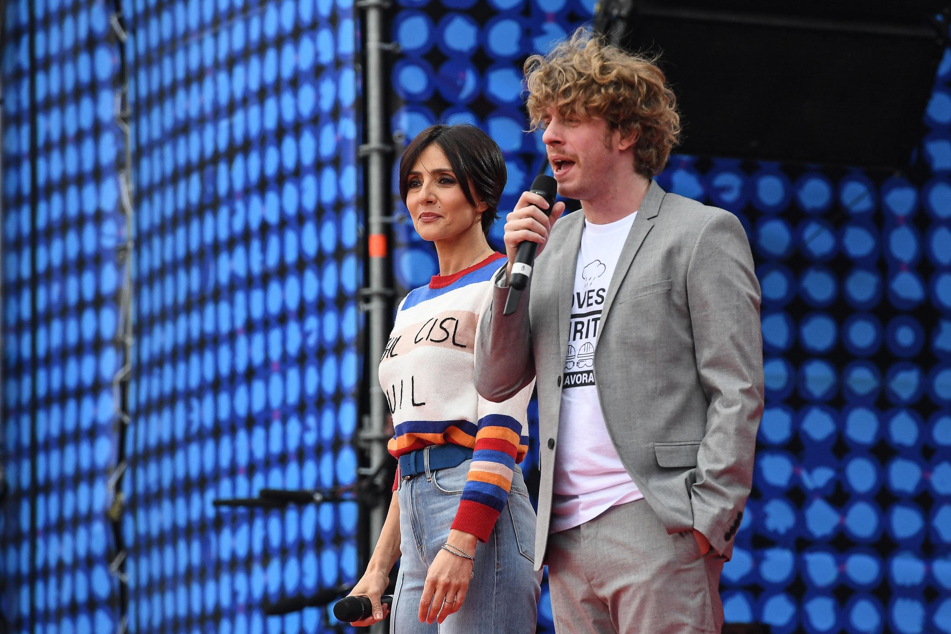 Concerto del Primo Maggio con Ambra e Lodo Guenzi. E lei indossa un maglione con le sigle dei sindacati