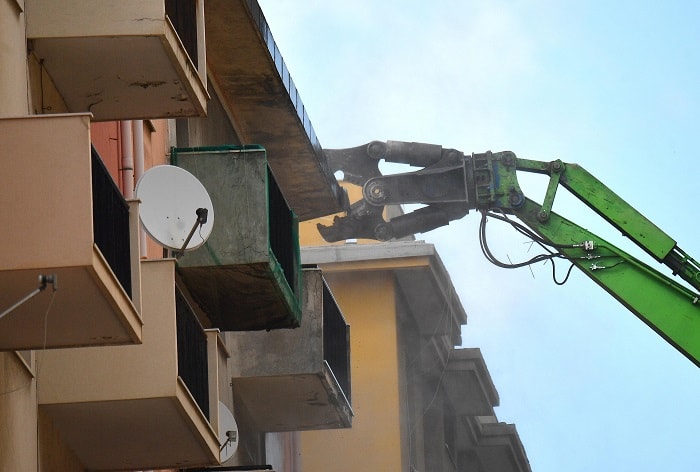 pinza meccanica abbatte palazzo ponte morandi