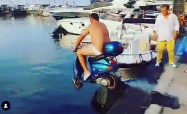 Catello, in costume, tenta il tuffo in mare con lo scooter dopo la scommessa con Mario Balotelli.