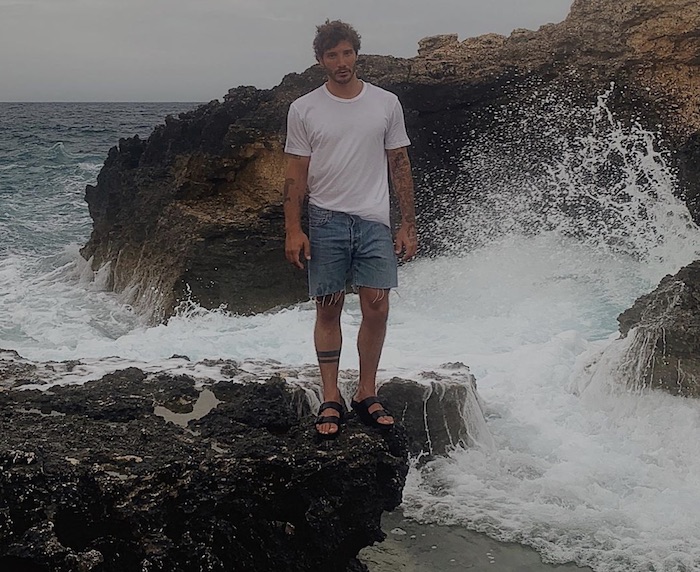 Stefano De Martino spaventa i fan: la foto in ciabatte sullo scoglio col mare agitato