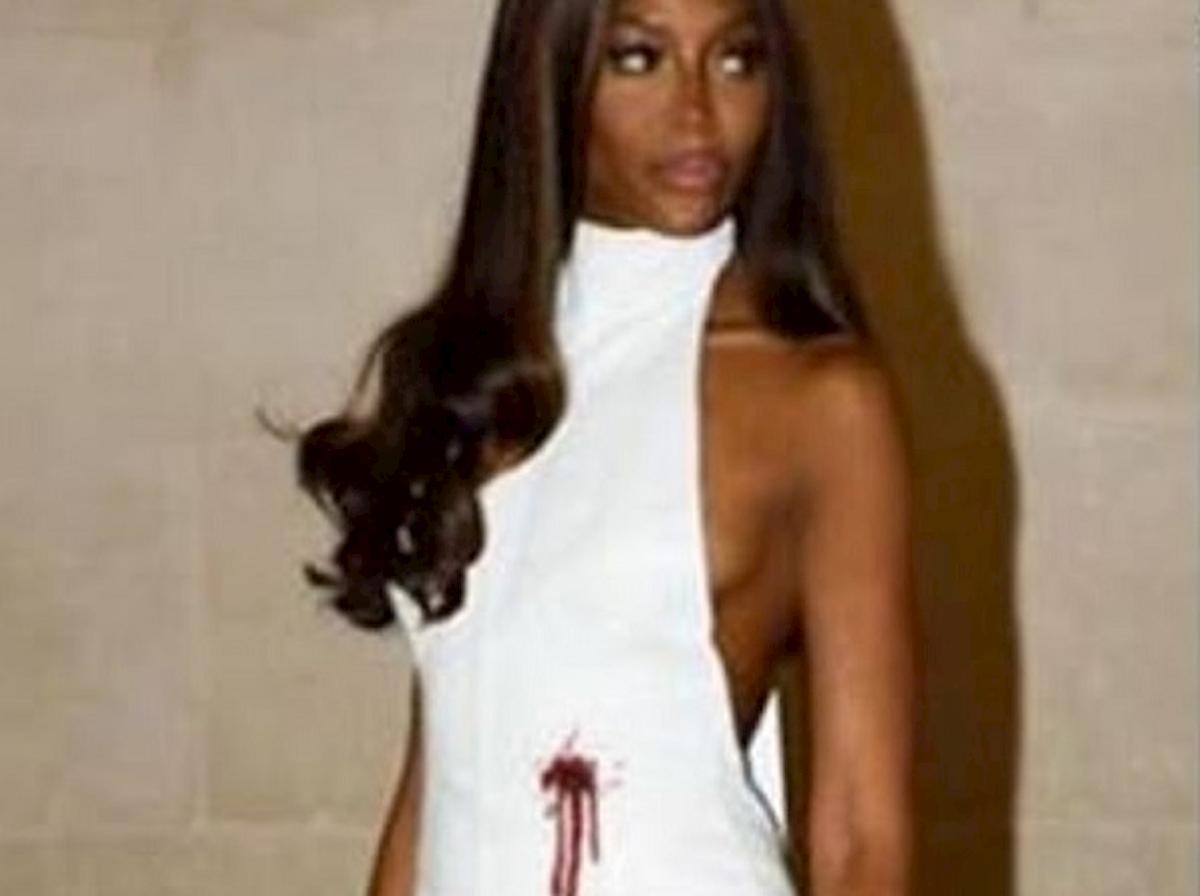 Naomi Cambell col vestito bianco macchiato di rosso come una ferita da arma da fuoco