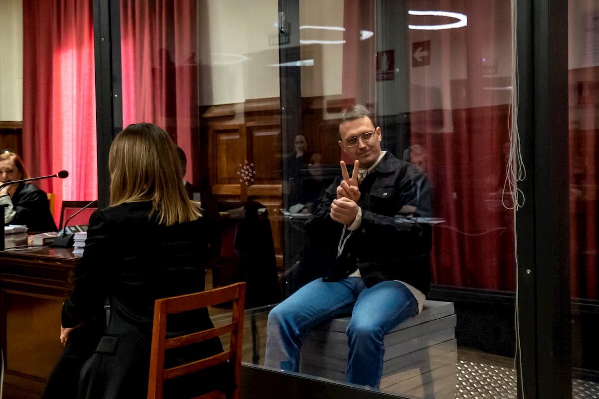 Igor il russo fa il segno di vittoria dalla gabbia di vetro durante il processo in Spagna