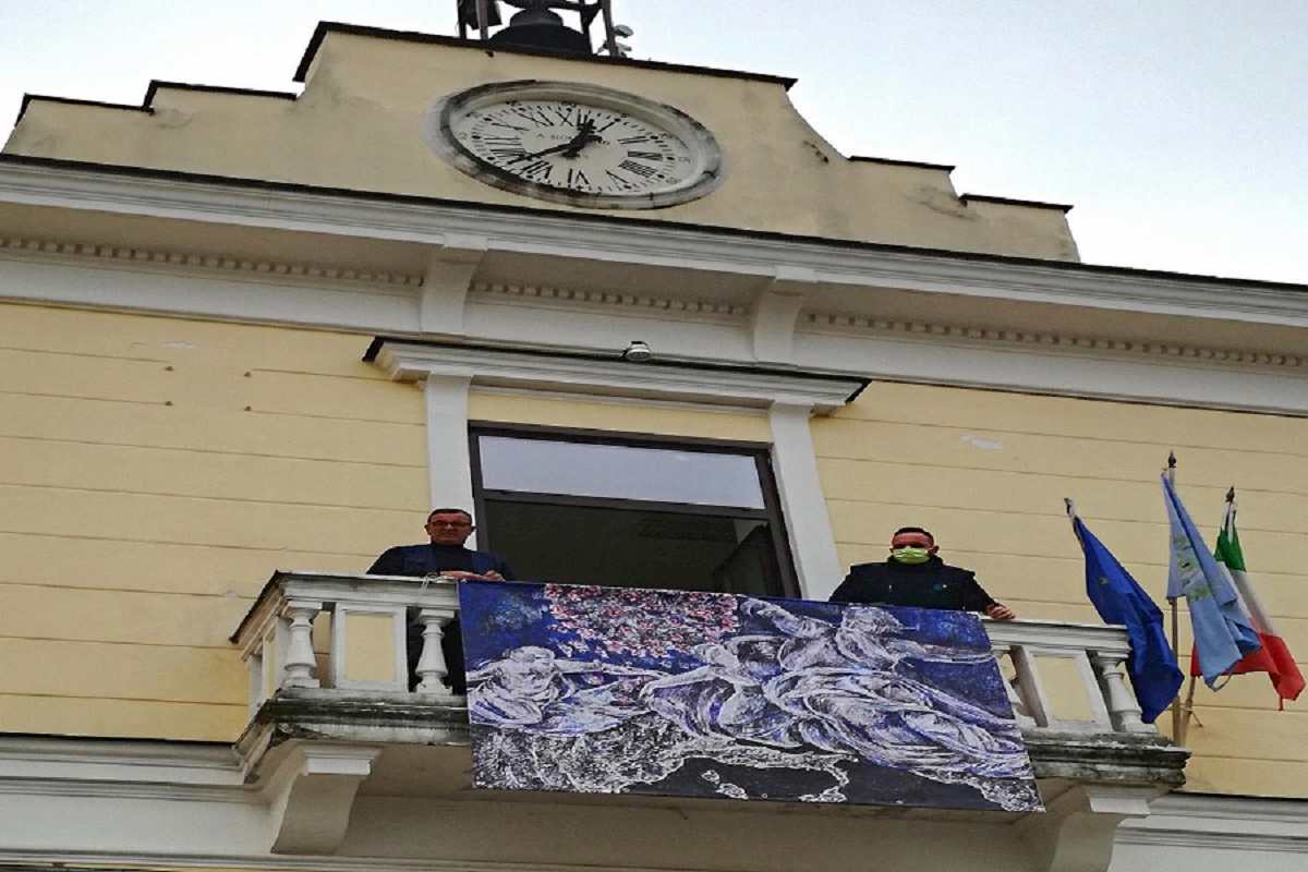 Cesa (Caserta), Dio smaterializza il Covid-19: la raffigurazione sulla facciata del comune