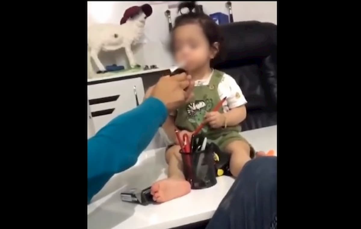 Bimba di 3 anni fuma una sigaretta e lo zio ride