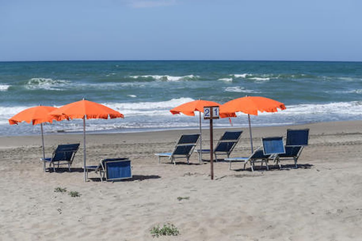 Coronavirus da spiaggia (nella foto Ansa): come si fa a abbronzarsi con la mascherina?