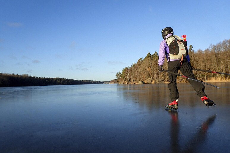 Pattinatrice cade nel lago ghiacciato, passante la salva tirandole un guinzaglio per cani