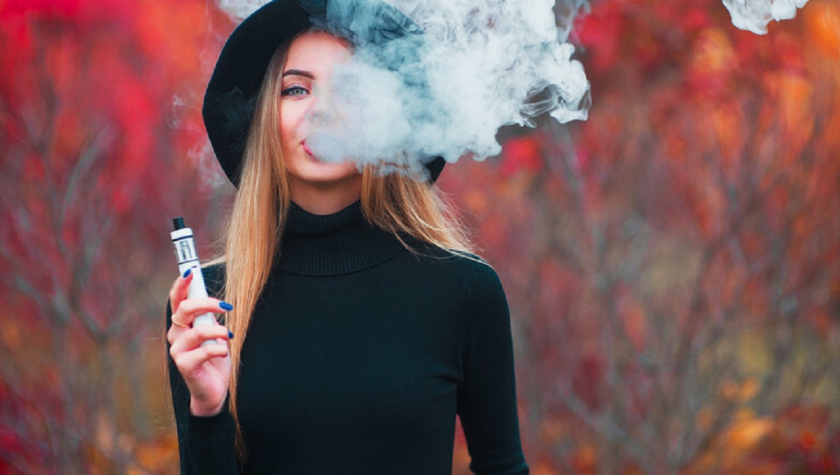 una donna fuma una sigaretta elettronica